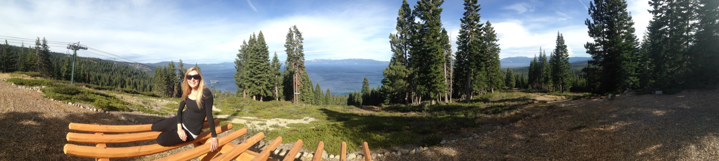 A wide panorama over an alpine lake from a forested overlook